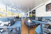 Luxurious yacht deck with blue seating, chevron pillows, and wooden flooring, Custom Compositeworks 2006.