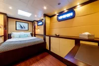 Luxurious yacht bedroom with modern decor, featuring a cozy bed and nautical artwork.