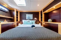 Luxurious yacht bedroom with modern decor, featuring a cozy bed and elegant lighting.