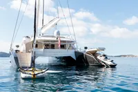 Luxurious 2006 Custom Compositeworks yacht with jet ski and sailboat on calm water.