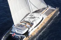 Luxury sailing catamaran on open sea, Custom Compositeworks 2006 model, aerial view.