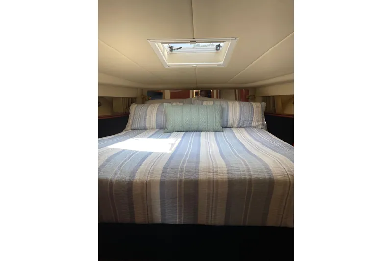  Yacht Photos Pics Cozy bedroom interior of 2003 Sea Ray 550 Sundancer yacht with striped bedding.