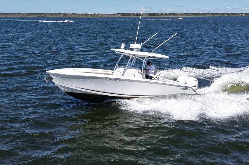  Yacht Photos Pics 2014 Jupiter 30 FS boat cruising on open water with a person onboard.