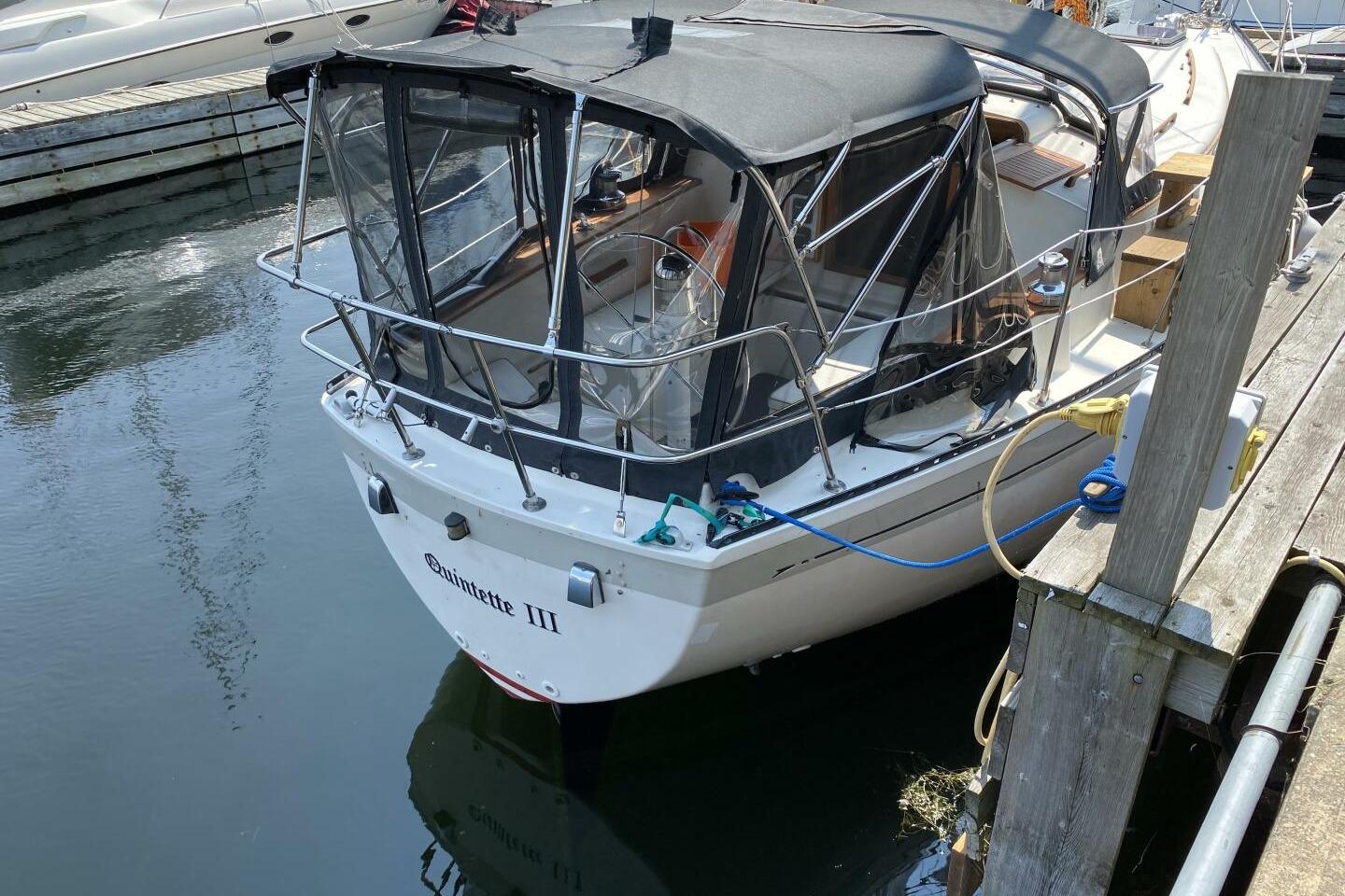 1984 Aloha 34 sailboat docked, featuring a covered cockpit and sleek design.