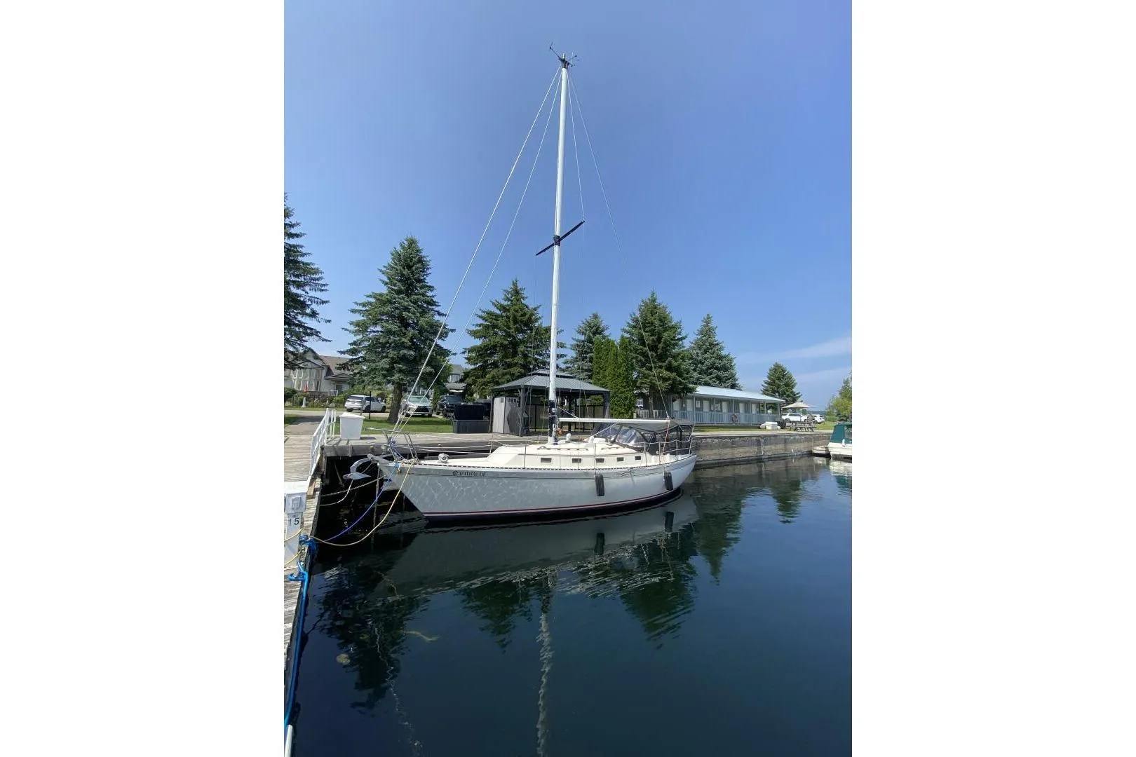 1984 Aloha 34 sailboat docked in a serene marina setting.