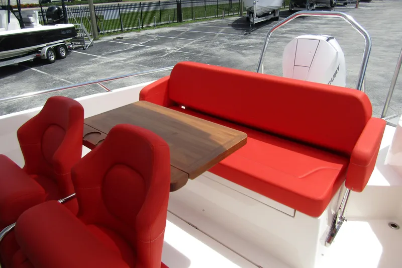  Yacht Photos Pics 2024 Nimbus T8 boat interior with red seating and wooden table.