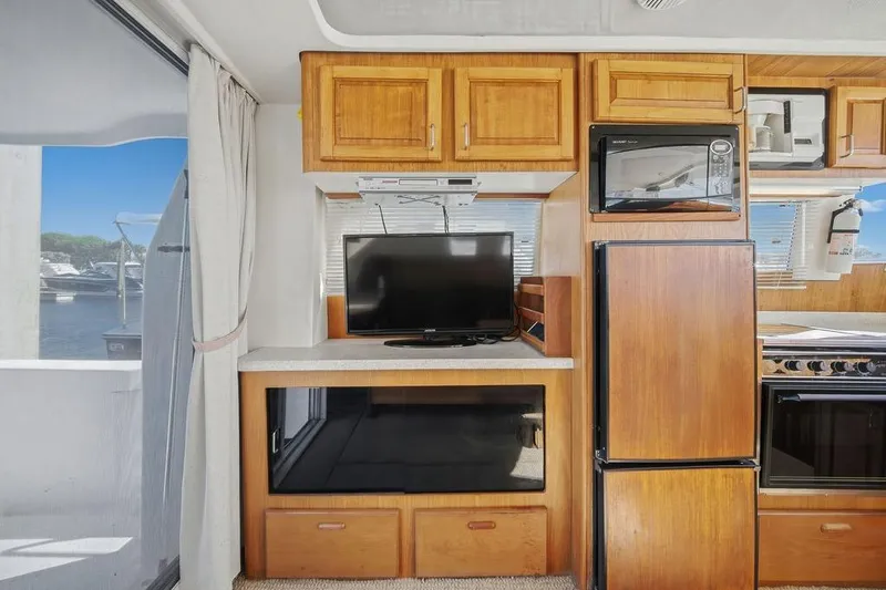  Yacht Photos Pics Interior of 1998 Mainship 350 Trawler with TV, microwave, and wooden cabinetry.