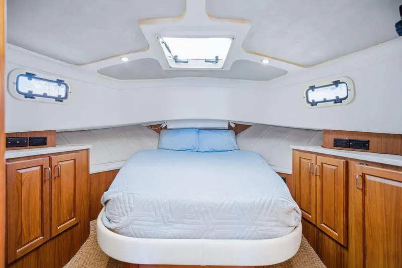  Yacht Photos Pics Cozy cabin interior of 1998 Mainship 350 Trawler with bed and wooden cabinets.
