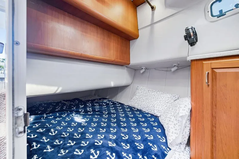  Yacht Photos Pics Cozy cabin interior of 1998 Mainship 350 Trawler with nautical-themed bedding.