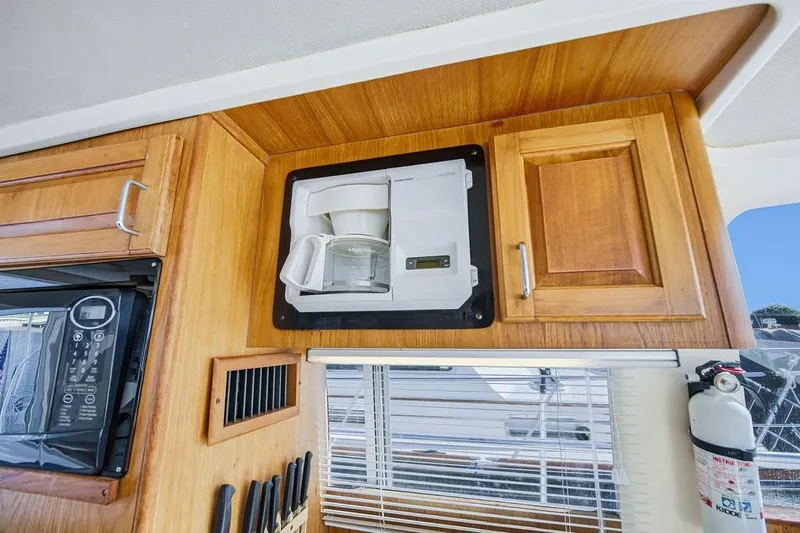  Yacht Photos Pics 1998 Mainship 350 Trawler interior with built-in coffee maker and wooden cabinetry.