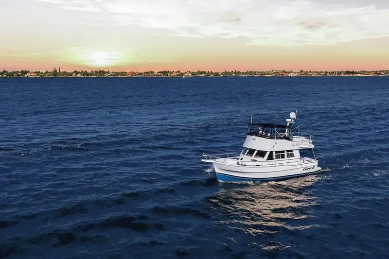  Yacht Photos Pics 1998 Mainship 350 Trawler cruising on ocean at sunset, scenic coastal view.