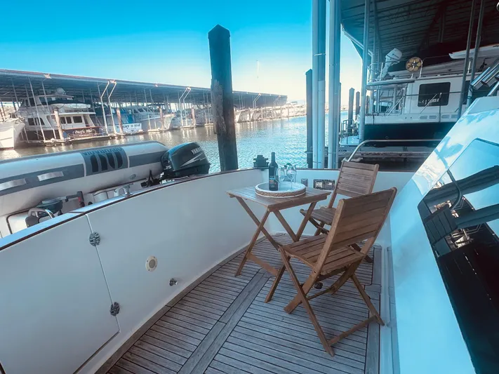 Westwind Yacht Photos Pics Deck of 2004 Westcoast 46 yacht with wooden chairs and table, marina view.