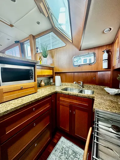 Westwind Yacht Photos Pics Luxurious 2004 Westcoast 46 yacht kitchen with wood cabinetry and granite countertops.