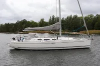 2007 Dufour 40 Performance sailboat on calm water, surrounded by lush greenery.