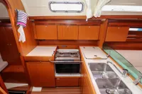 Interior of 2007 Dufour 40 Performance yacht kitchen with wood cabinetry and stainless steel sink.