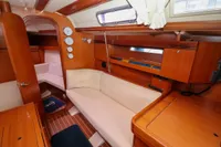 Interior of 2007 Dufour 40 Performance yacht with wooden finish and cozy seating area.