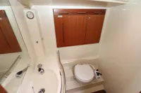 2007 Dufour 40 Performance yacht bathroom with sink, toilet, and wooden cabinets.