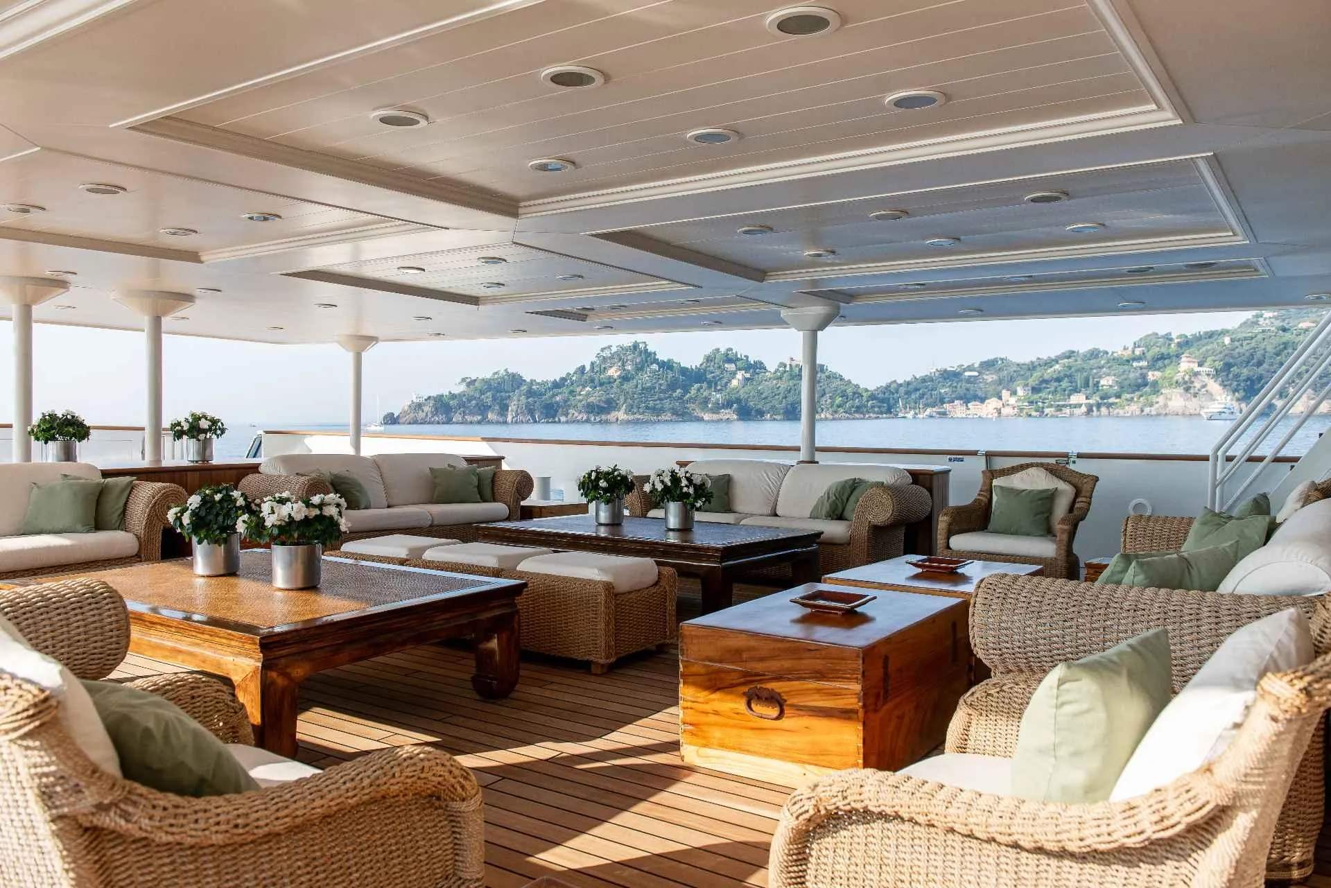 Luxurious yacht deck with wicker furniture, wooden tables, and ocean view, Custom Conversion 1980.