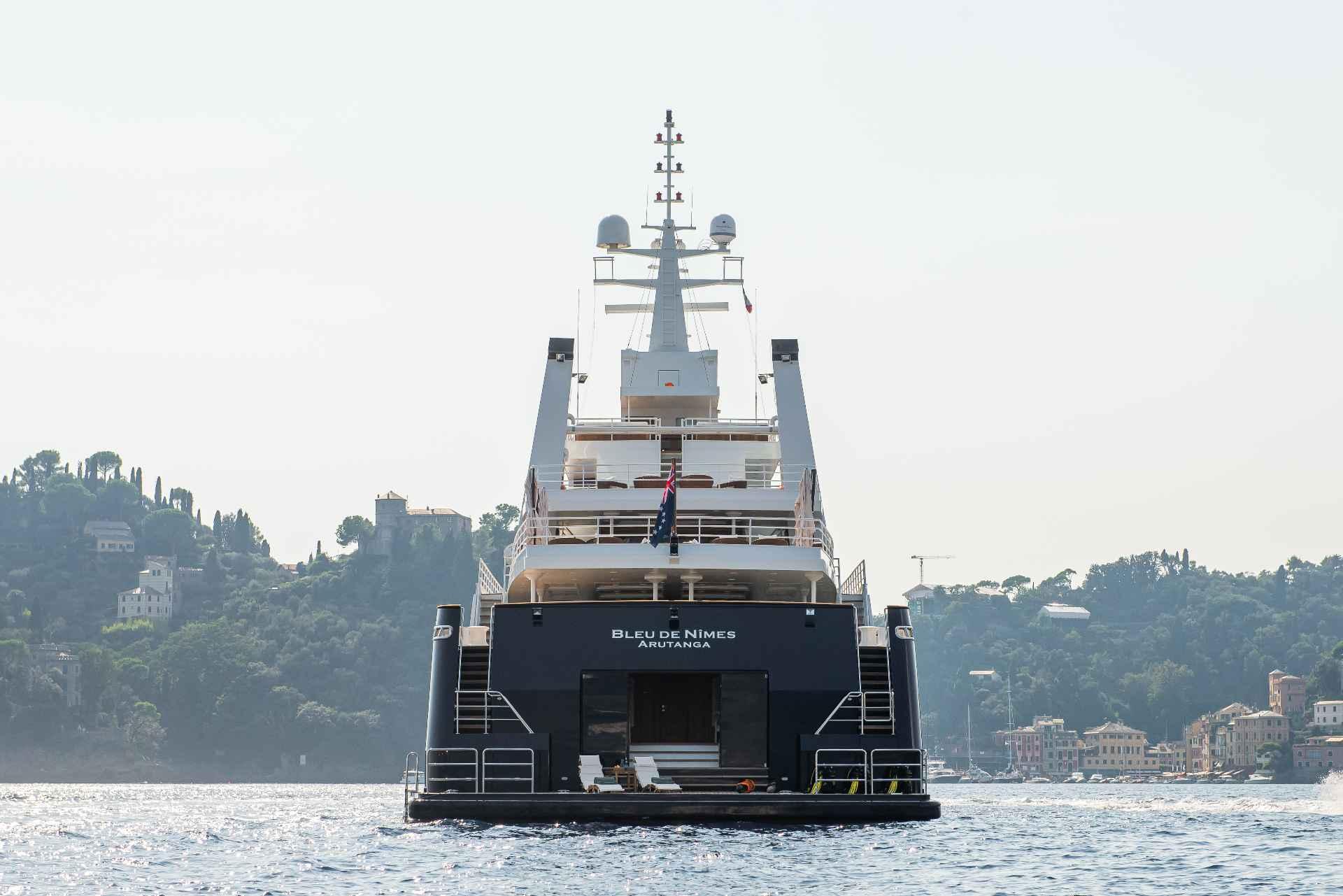 Luxury yacht on water, Custom Conversion 1980, with scenic coastal backdrop.