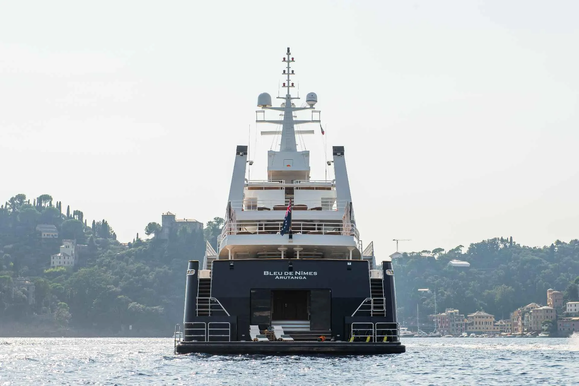 Luxury yacht on water, Custom Conversion 1980, with scenic coastal backdrop.