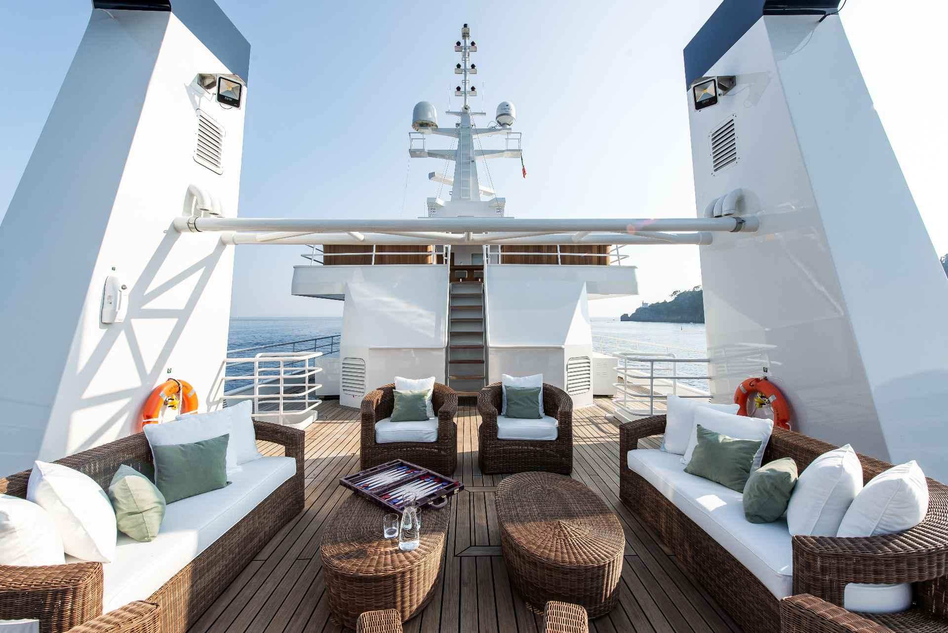 Luxurious yacht deck with wicker furniture, cushions, and ocean view, Custom Conversion 1980 model.