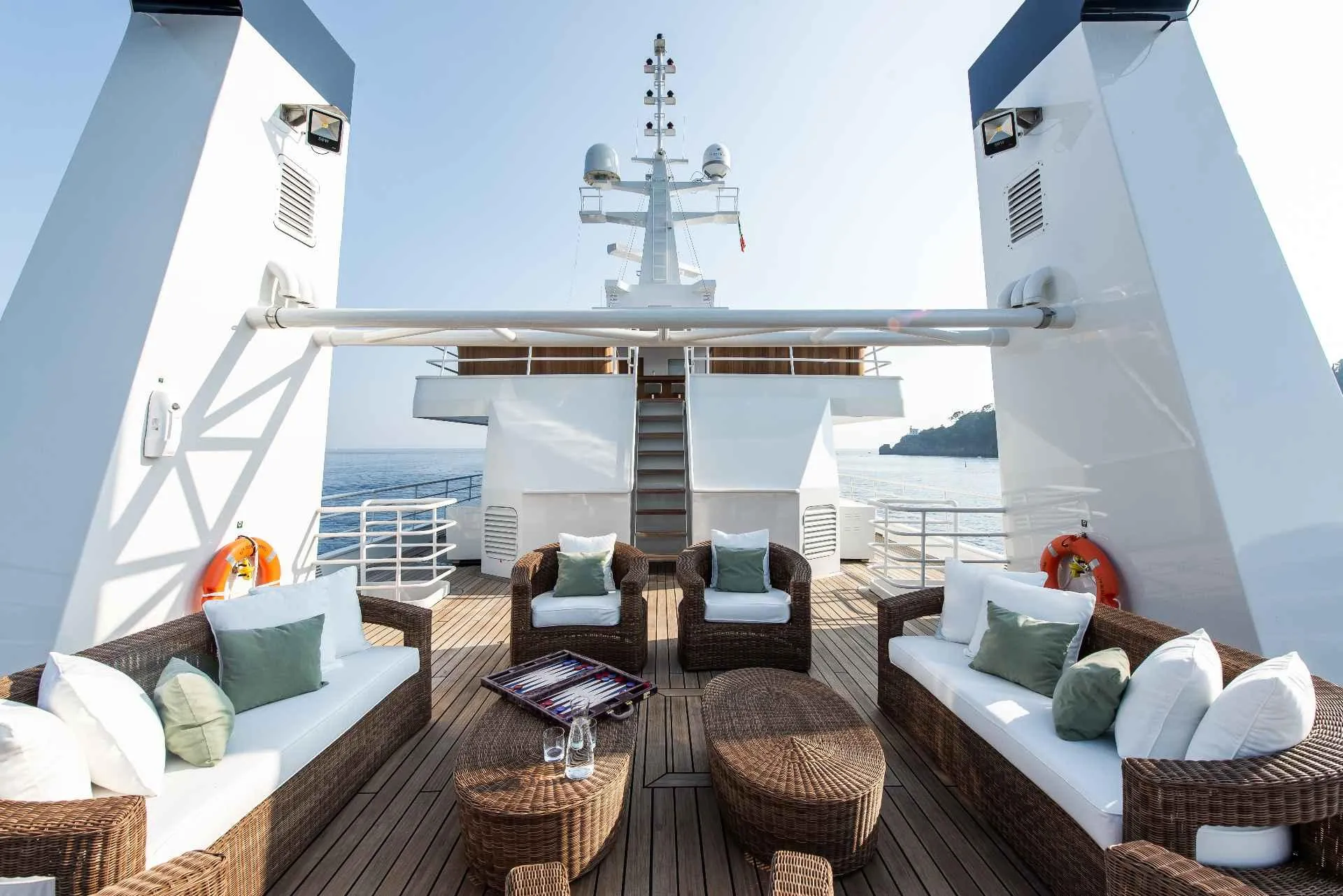 Luxurious yacht deck with wicker furniture, cushions, and ocean view, Custom Conversion 1980 model.