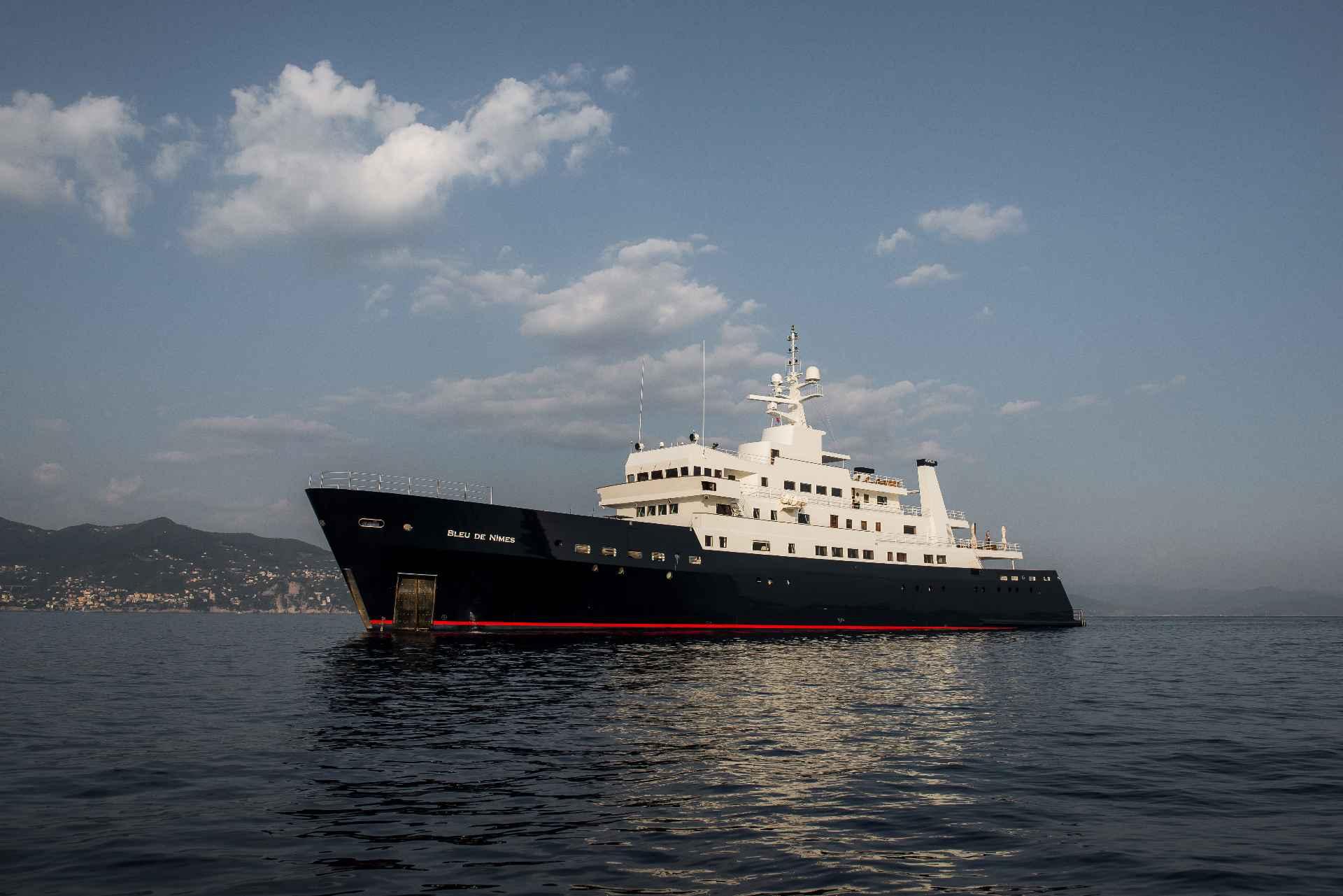Large custom conversion yacht from 1980 on calm sea under cloudy sky.
