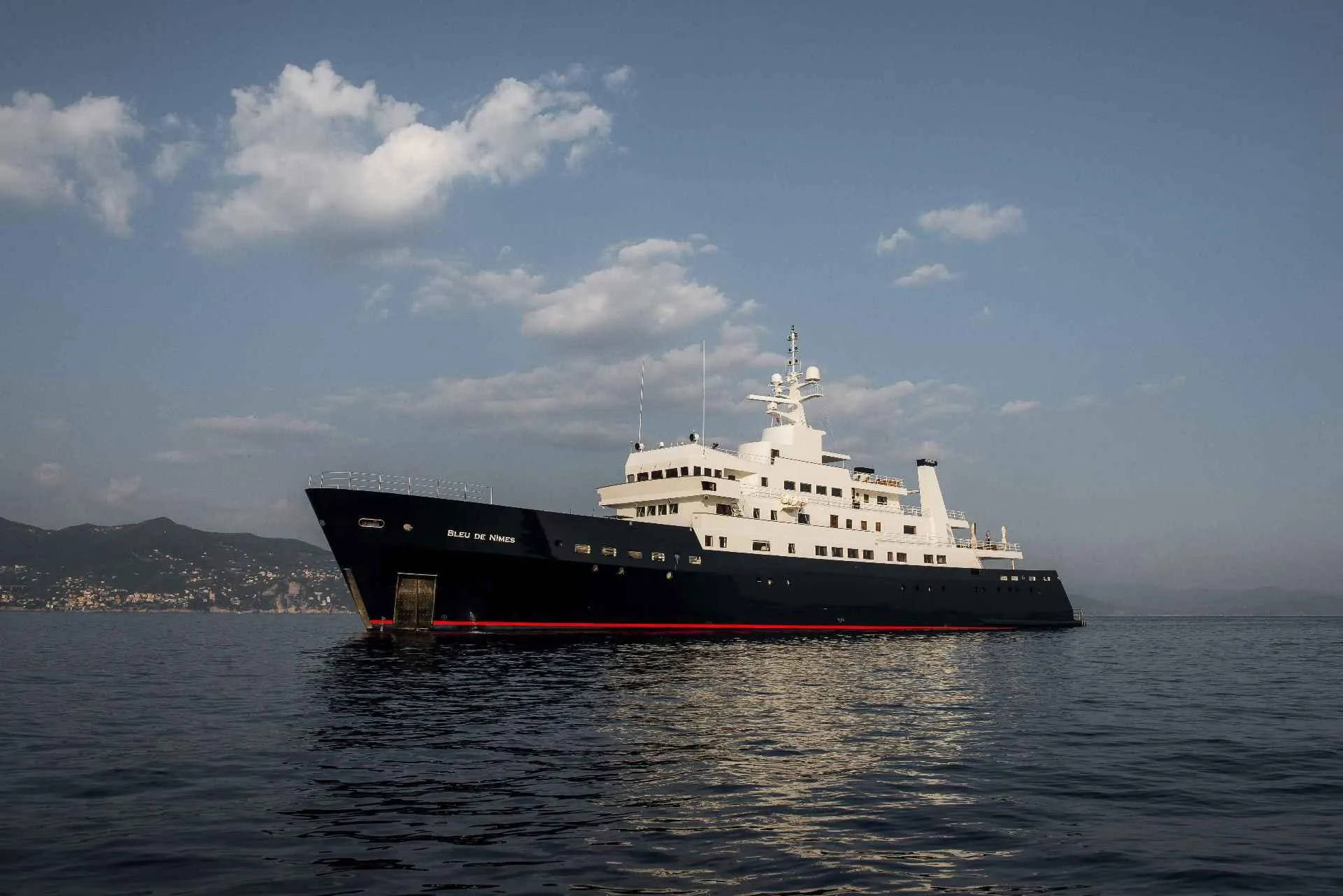 Large custom conversion yacht from 1980 on calm sea under cloudy sky.