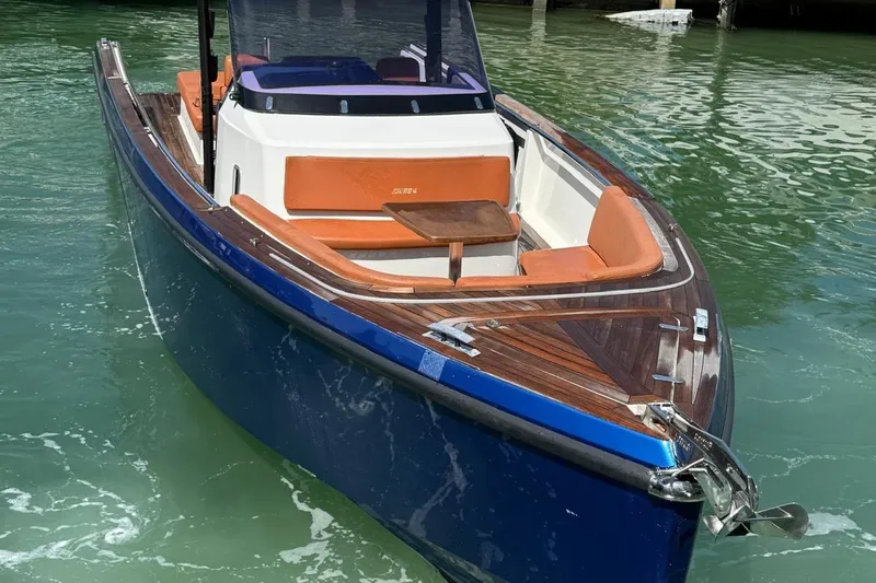  Yacht Photos Pics 2017 Fjord 36' Open boat with blue hull and orange seating on water.