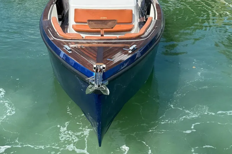  Yacht Photos Pics 2017 Fjord 36' Open boat with wooden deck, anchored in clear water.
