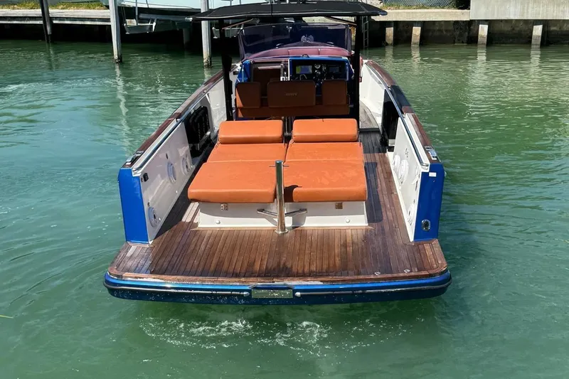  Yacht Photos Pics 2017 Fjord 36' Open boat with brown seating, docked on calm water.