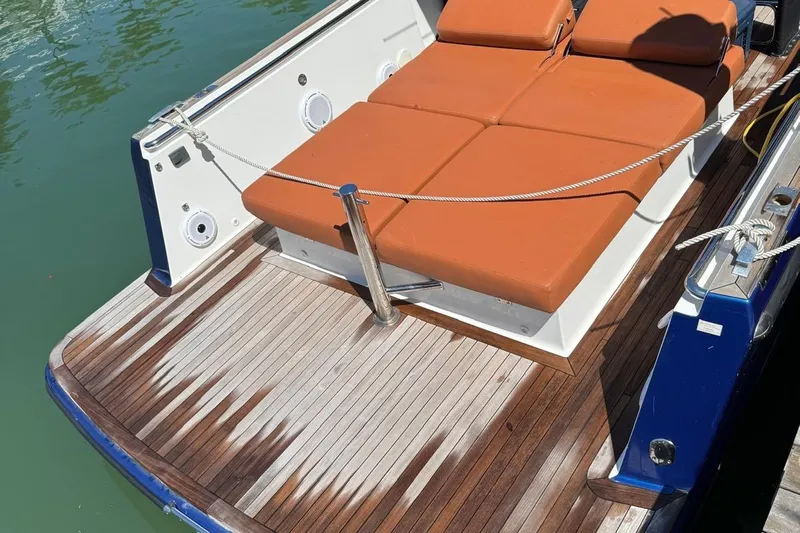  Yacht Photos Pics 2017 Fjord 36' Open boat with teak deck and orange sunbed cushions.