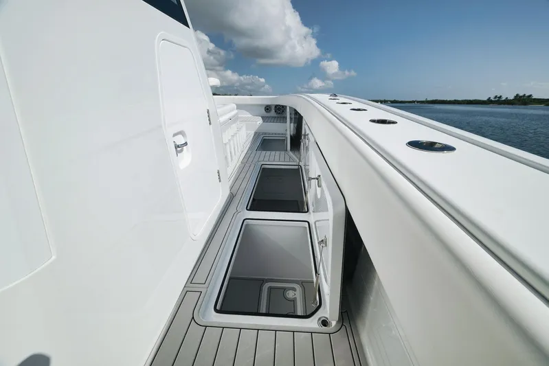  Yacht Photos Pics Freeman 47 boat deck with open storage compartments, 2022 model, on calm water.