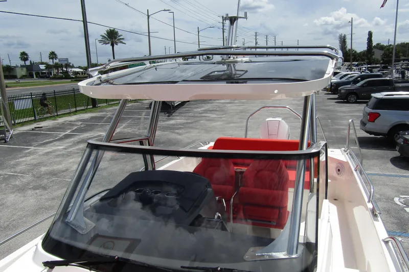  Yacht Photos Pics 2024 Nimbus T8 boat with red seating and sleek design in a parking lot.