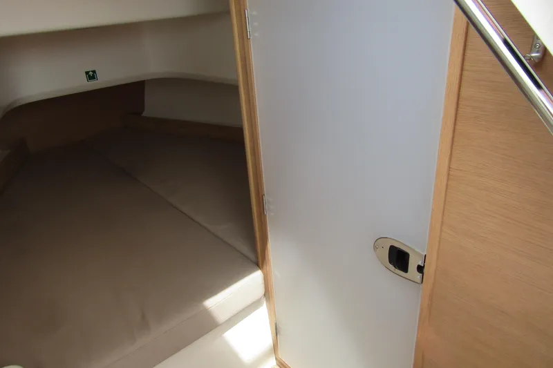  Yacht Photos Pics 2024 Nimbus T8 cabin interior with wooden door and cozy sleeping area.