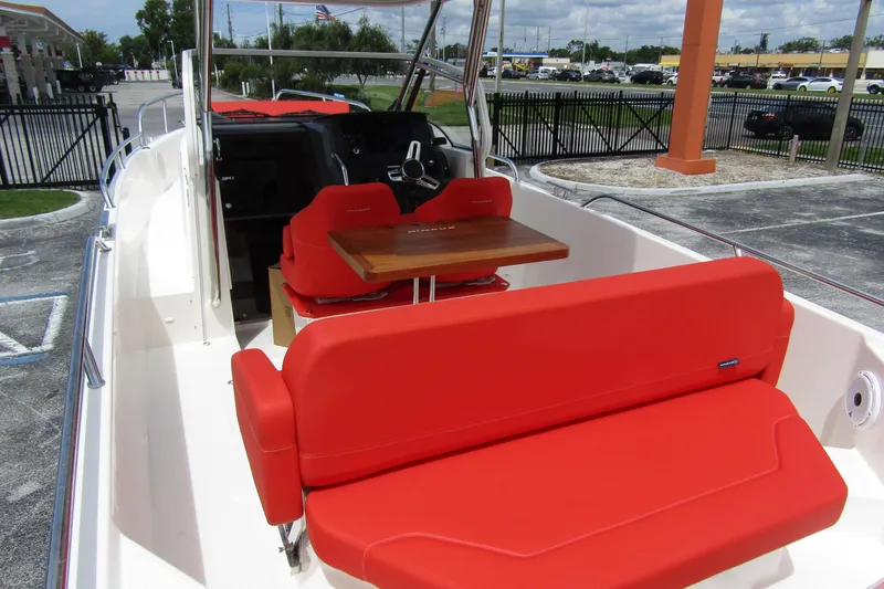  Yacht Photos Pics 2024 Nimbus T8 boat with vibrant red seating and a wooden table.