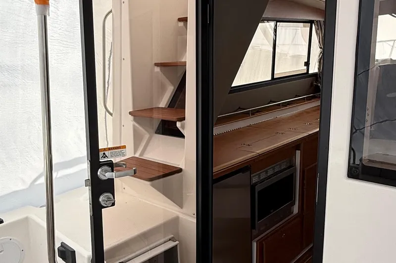  Yacht Photos Pics 2025 Cutwater C-32 CB interior with wooden stairs and kitchenette.