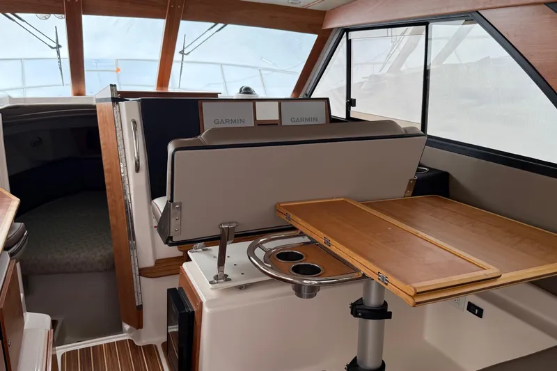  Yacht Photos Pics Interior of 2025 Cutwater C-32 CB boat with Garmin navigation and wooden table.