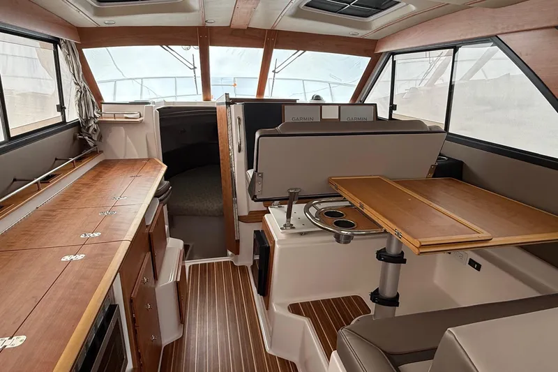  Yacht Photos Pics 2025 Cutwater C-32 CB interior with wood finishes and modern navigation equipment.