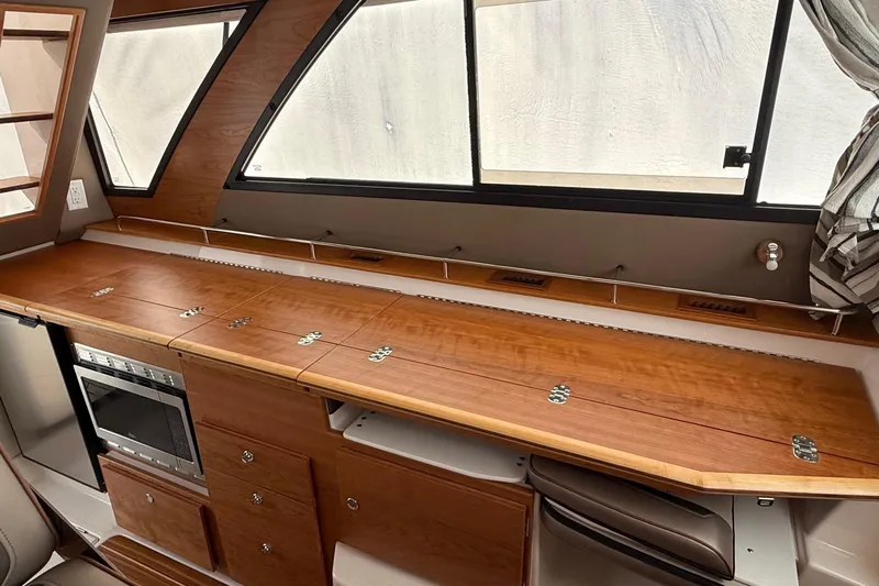  Yacht Photos Pics 2025 Cutwater C-32 CB interior with wooden cabinetry and modern appliances.