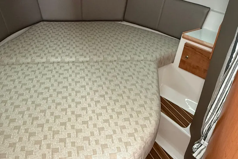  Yacht Photos Pics 2025 Cutwater C-32 CB cabin interior with patterned bedding and wooden accents.