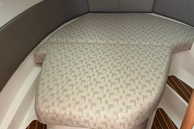  Yacht Photos Pics 2025 Cutwater C-32 CB cabin interior with patterned bedding and wooden flooring.