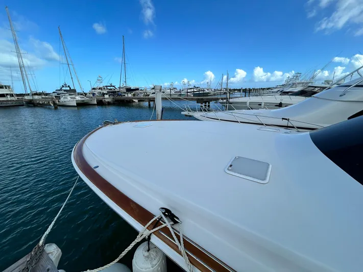 Carisa Yacht Photos Pics 2001 Viking 55 Convertible yacht docked in a marina under a clear blue sky.