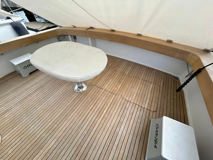 Carisa Yacht Photos Pics 2001 Viking 55 Convertible yacht deck with wooden flooring and round table.