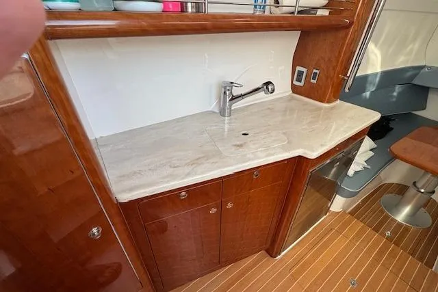  Yacht Photos Pics 2016 Intrepid 475 Panacea yacht interior with wooden cabinetry and marble countertop.