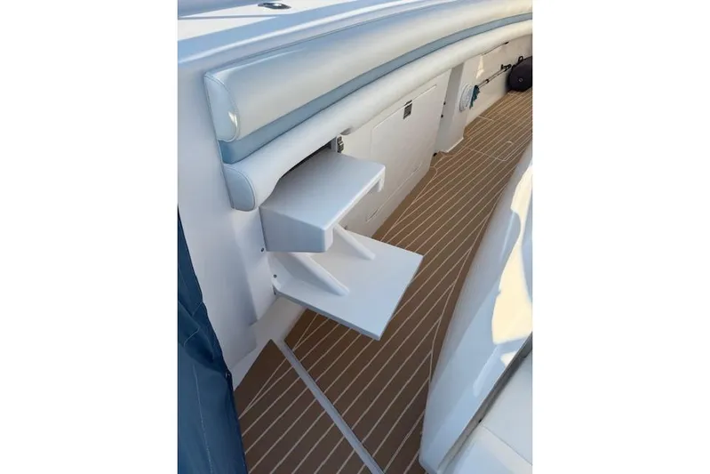  Yacht Photos Pics 2016 Intrepid 475 Panacea boat interior with foldable steps and cushioned seating.