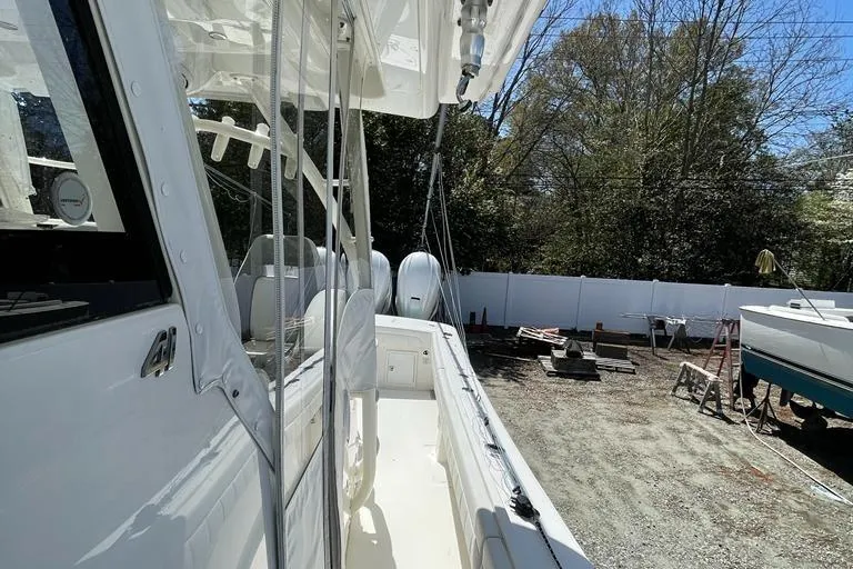  Yacht Photos Pics 2019 Regulator 41 boat docked, side view with trees and equipment in the background.