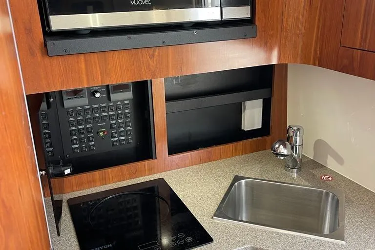  Yacht Photos Pics 2019 Regulator 41 boat interior with kitchenette, featuring sink, stovetop, and microwave.