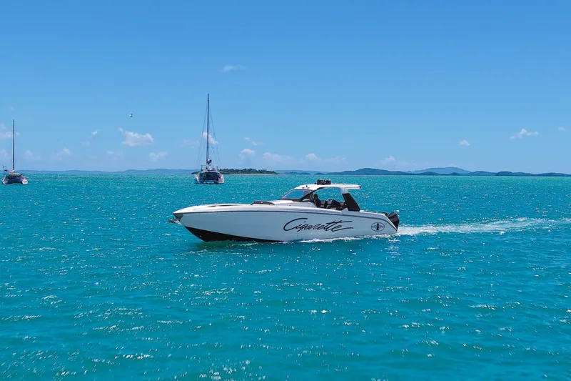  Yacht Photos Pics 2025 Cigarette 42 Auroris speedboat cruising on turquoise ocean with sailboats in the background.