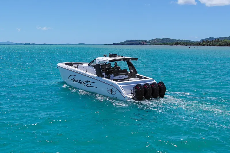 Yacht Photos Pics 2025 Cigarette 42 Auroris boat cruising on turquoise waters under clear blue sky.